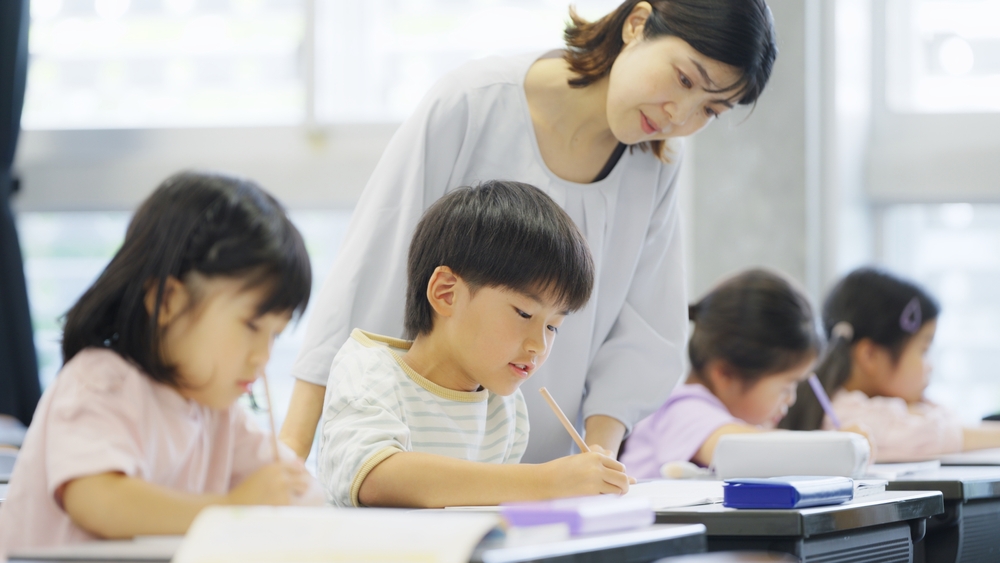 教室で問題を解いている生徒たち一人ひとりを丁寧にみて回る先生の様子。